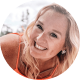 Breanna Barnes Headshot of a smiling woman with long blonde hair wearing an orange top, taken outdoors.